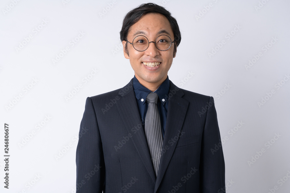 Portrait of happy Japanese businessman in suit smiling Portrait of happy Japanese businessman in suit smiling