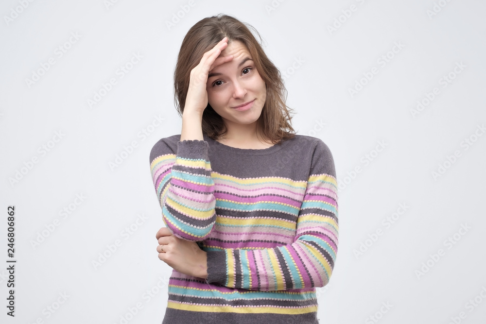 Good looking young female giggles joyfully, covers face as tries stop laughing Good looking young female giggles joyfully, covers face as tries stop laughing