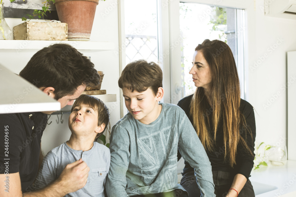 Portrait of a happy family kissing and hugging at home. Family lifestyle showing affection Portrait of a happy family kissing and hugging at home. Family lifestyle showing affection