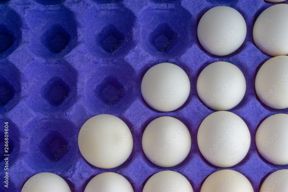 White eggs closeup in egg tray with selective focus and crop fragment White eggs closeup in egg tray with selective focus and crop fragment