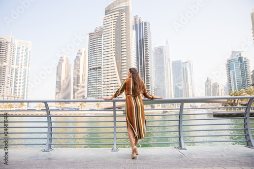 Photography Rear view of happy beautiful tourist woman in fashionable summer white dress enjoying in Dubai marina in United Arab Emirates