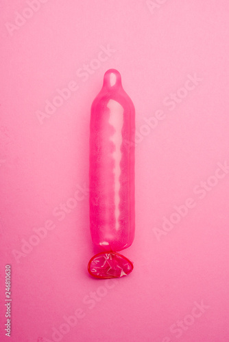 Pink condom on pink background
