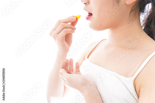 薬・サプリメントを飲む若い女性