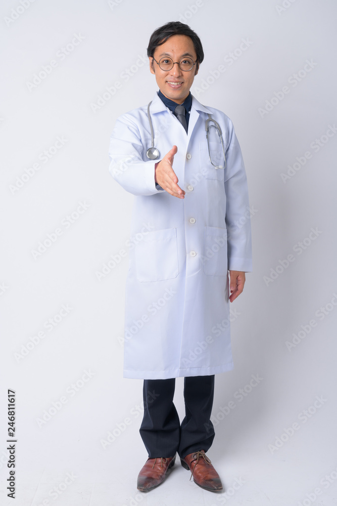 Full body shot of happy Japanese man doctor giving handshake Full body shot of happy Japanese man doctor giving handshake