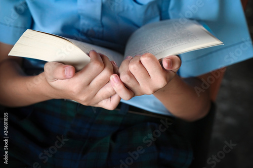 elementary school kid reads and holds the bigbook in his hand.