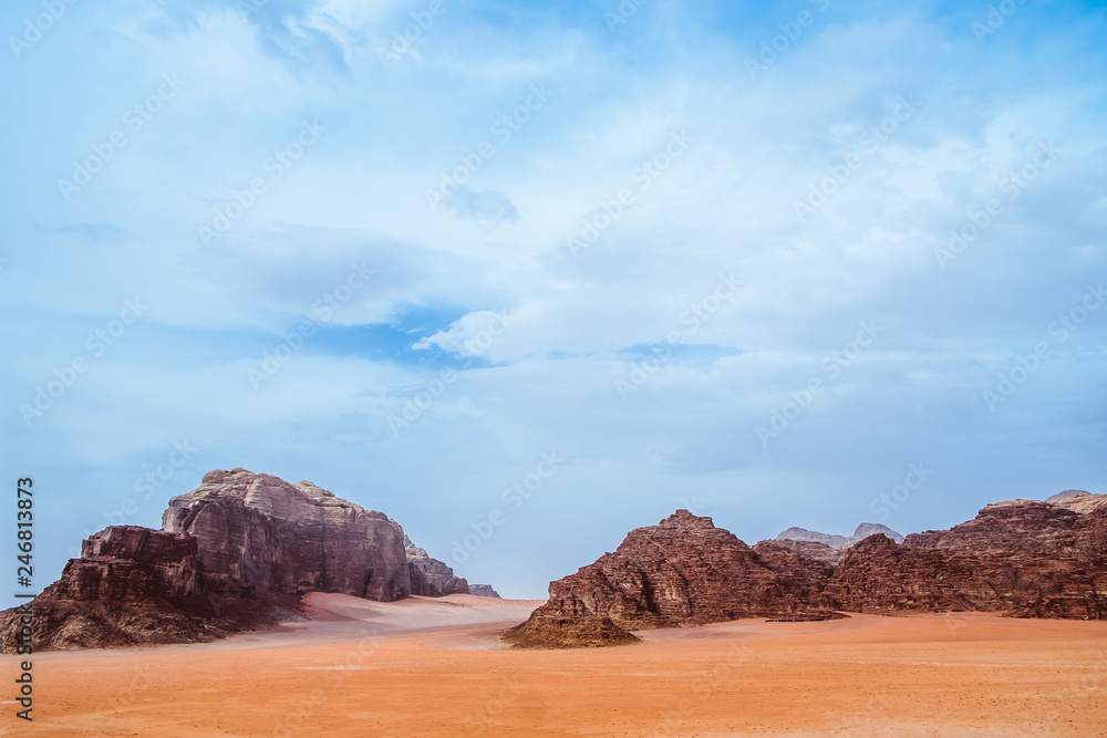 Fototapeta premium Red mountains of the canyon of Wadi Rum desert in Jordan. Wadi Rum also known as The Valley of the Moon is a valley cut into the sandstone and granite rock in southern Jordan to the east of Aqaba.