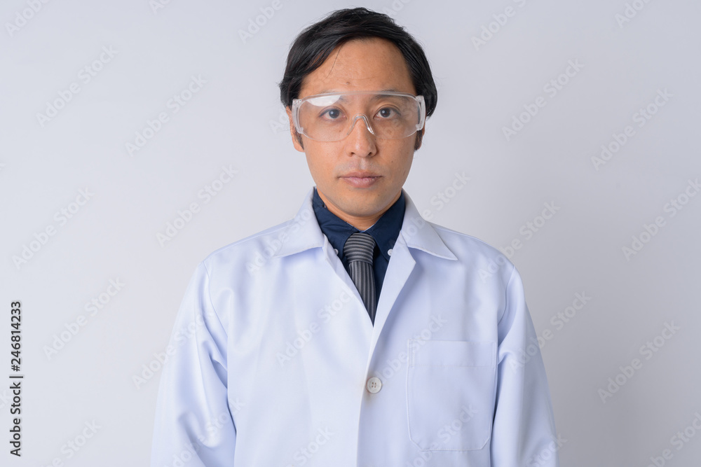 Japanese man doctor wearing protective glasses and looking at camera Japanese man doctor wearing protective glasses and looking at camera