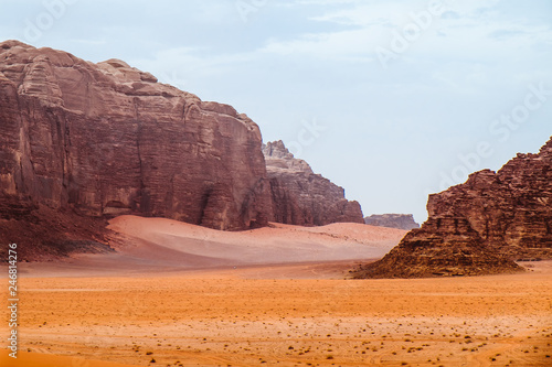 Red mountains of the canyon of Wadi Rum desert in Jordan. Wadi Rum also known as The Valley of the Moon is a valley cut into the sandstone and granite rock in southern Jordan to the east of Aqaba.