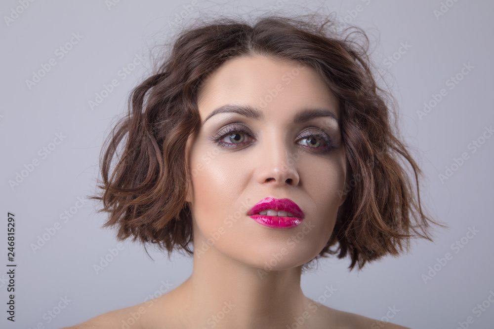 Portrait of a beautiful woman with short wavy hair and bright lips. Portrait of a beautiful woman with short wavy hair and bright lips.