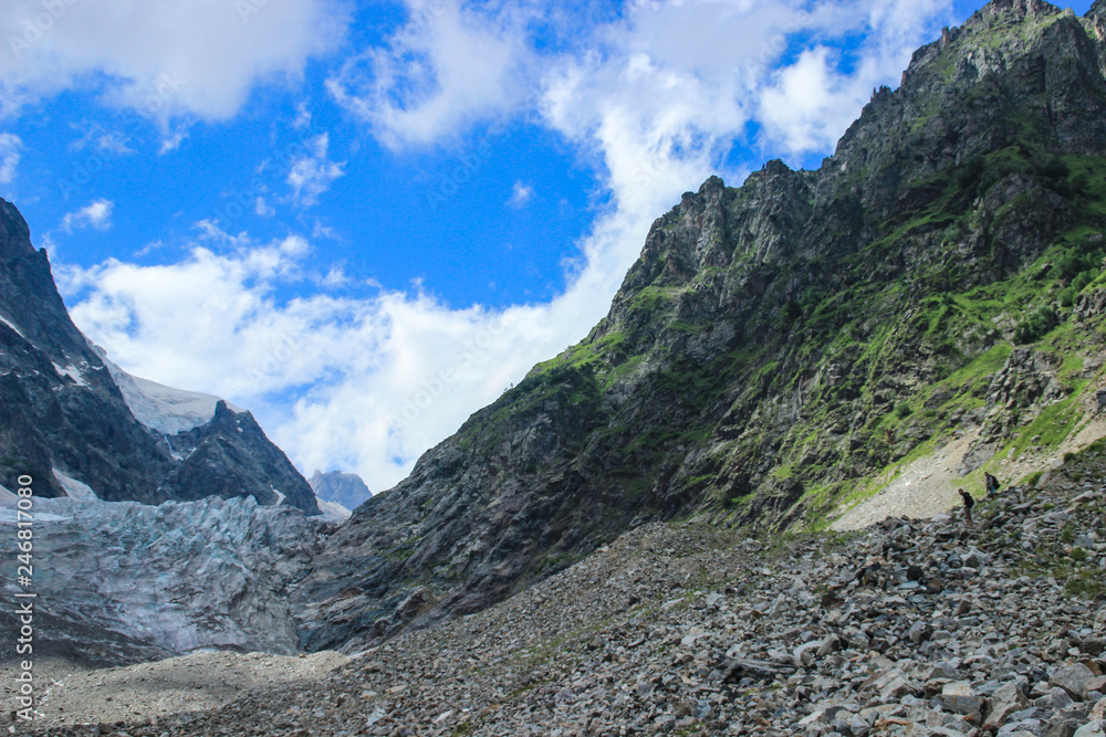 Mount Ushba in Svaneti. Georgia. Snowy top of the mountain surrounded by forest and stones.