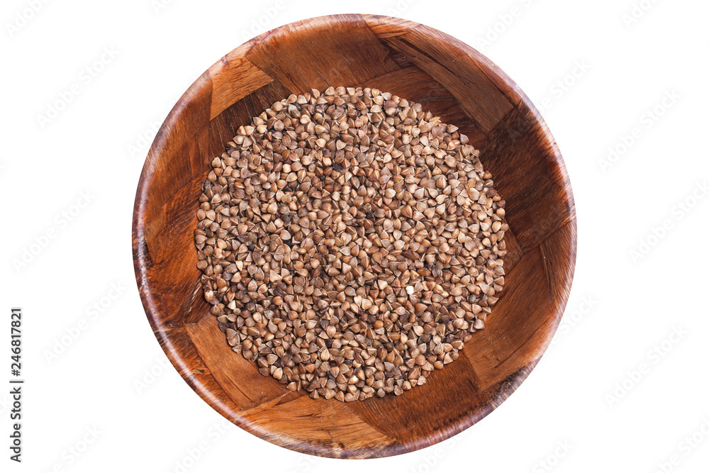 Brown buckwheat grain in wooden bowl isolated on white. Healthy food pattern background. Brown buckwheat grain in wooden bowl isolated on white. Healthy food pattern background.