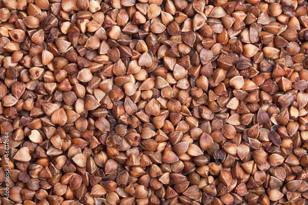 Brown buckwheat grain closeup texture. Healthy food pattern background. Brown buckwheat grain closeup texture. Healthy food pattern background.