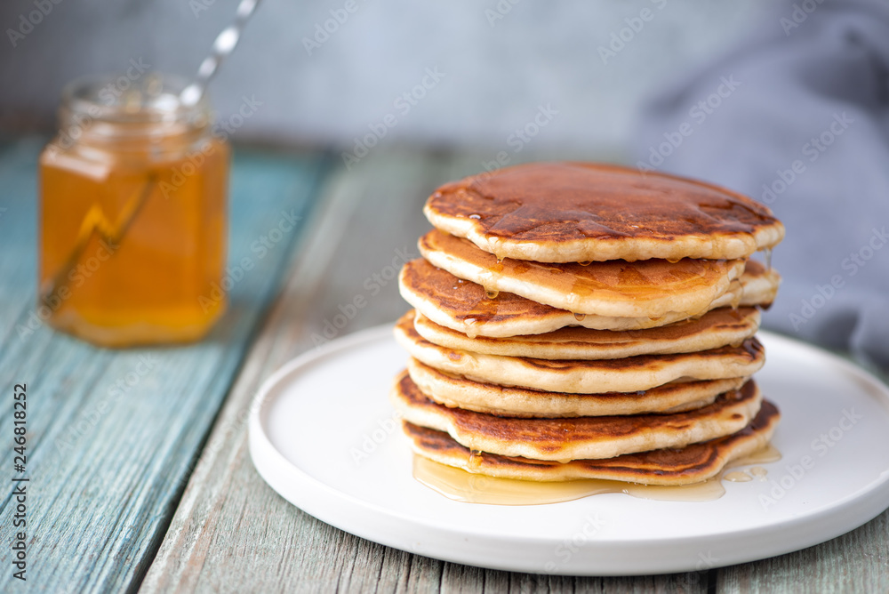 Sweet breakfast Pancakes with honey on a plate. Sweet breakfast Pancakes with honey on a plate.