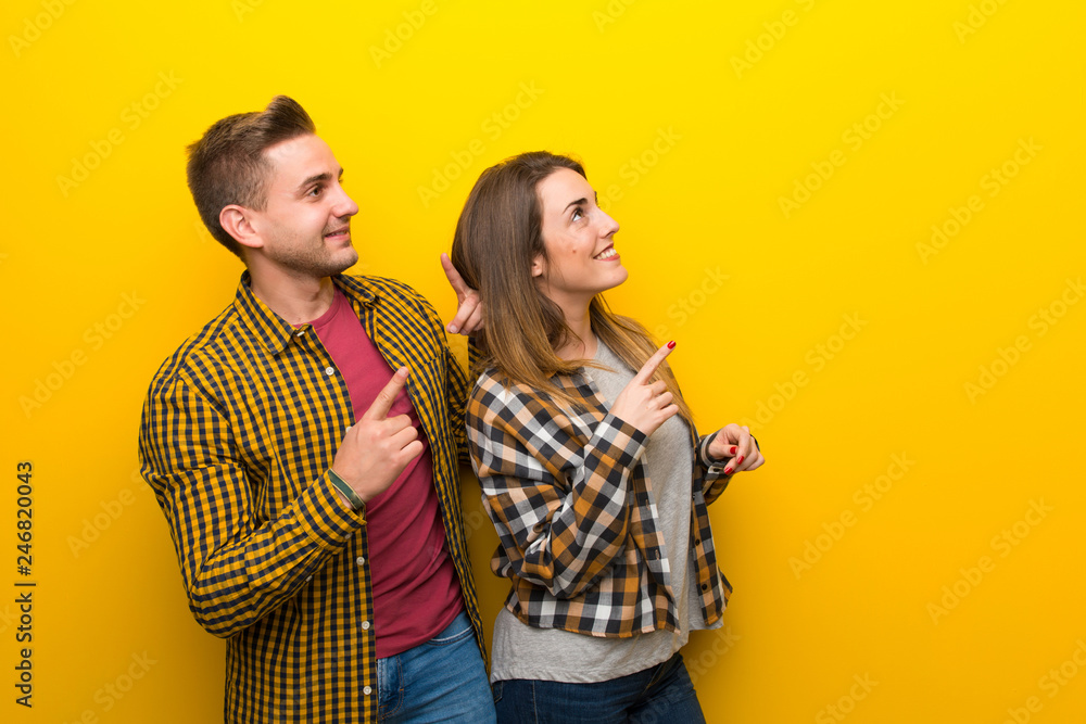 Couple in valentine day pointing up with the index Couple in valentine day pointing up with the index