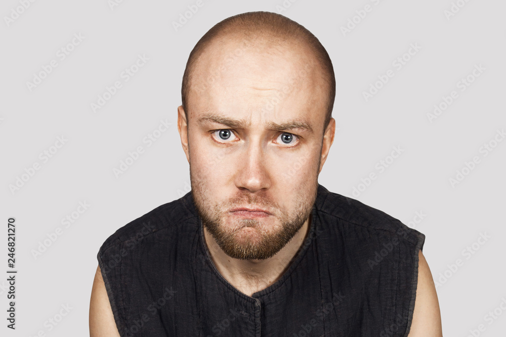 portrait of a bald upset offended man experiencing stress due to problems on gray background portrait of a bald upset offended man experiencing stress due to problems on gray background