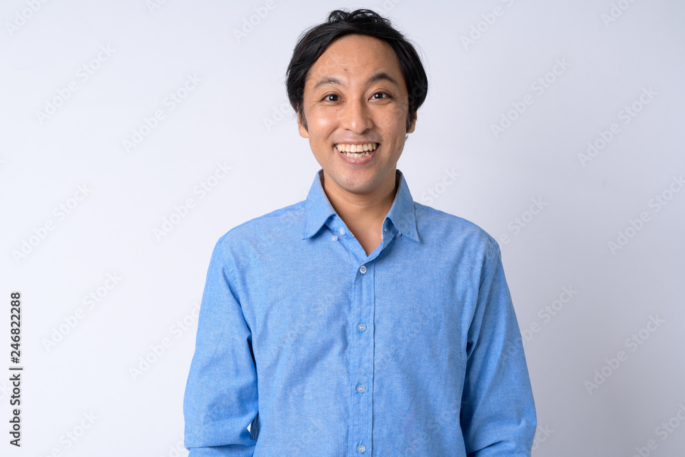 Portrait of happy Japanese businessman smiling against white background Portrait of happy Japanese businessman smiling against white background