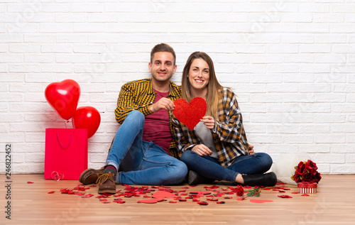 Couple in valentine day at indoors holding a heart symbol