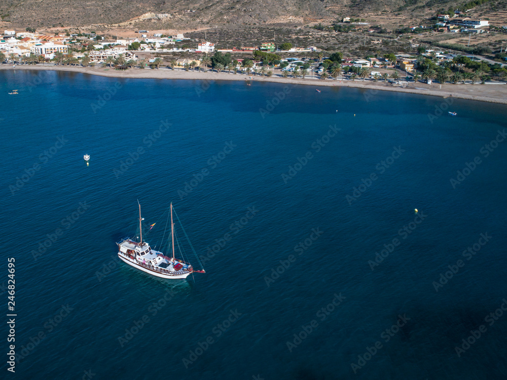 Obraz premium Aerial view photo of Luxury vintage two masted tourist trip ship stays on anchor in the bay, calm transparent water of mediterranean sea near Cartagena, Costa Blanca, Spain