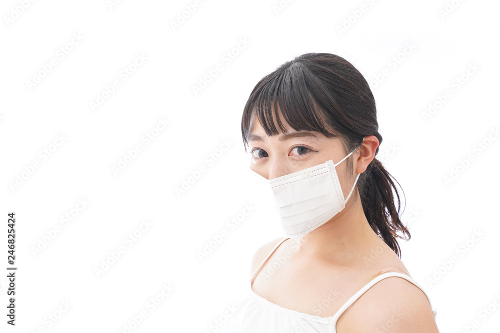 花粉症・風邪・インフルエンザに苦しみマスクをする若い女性