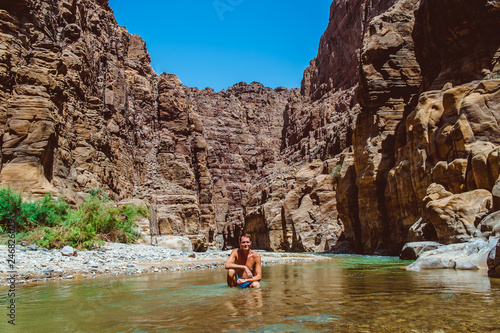 Young adventurous man in Wadi Zarqa Ma'in canyon located in the mountainous landscape to the east of the Dead Sea, near to Wadi Mujib, Jordan, Middle East