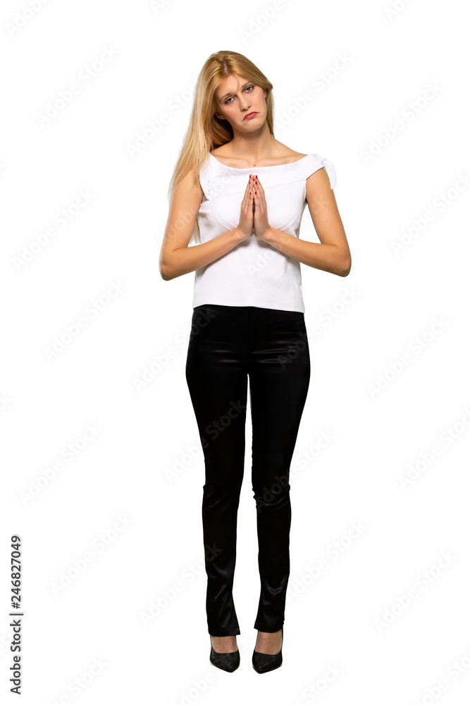 Young blonde woman keeps palm together. Person asks for something over isolated white background Young blonde woman keeps palm together. Person asks for something over isolated white background