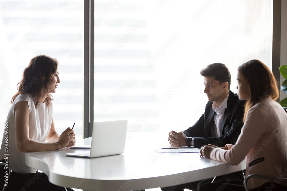 Diverse multi-ethnic business people communicating sitting at office meeting table, serious multiracial hr talking to applicant at job interview, recruitment, consulting and negotiations concept Diverse multi-ethnic business people communicating sitting at office meeting table, serious multiracial hr talking to applicant at job interview, recruitment, consulting and negotiations concept