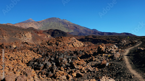 Path through the lunar landscape of Montana Samara in Teide National Park, one of the most alien-like, volcanic land in Tenerife with views towards Pico del Teide, Pico Viejo, and Las Cuevas Negras