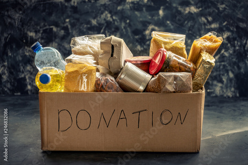 Donation box full of different products on dark background