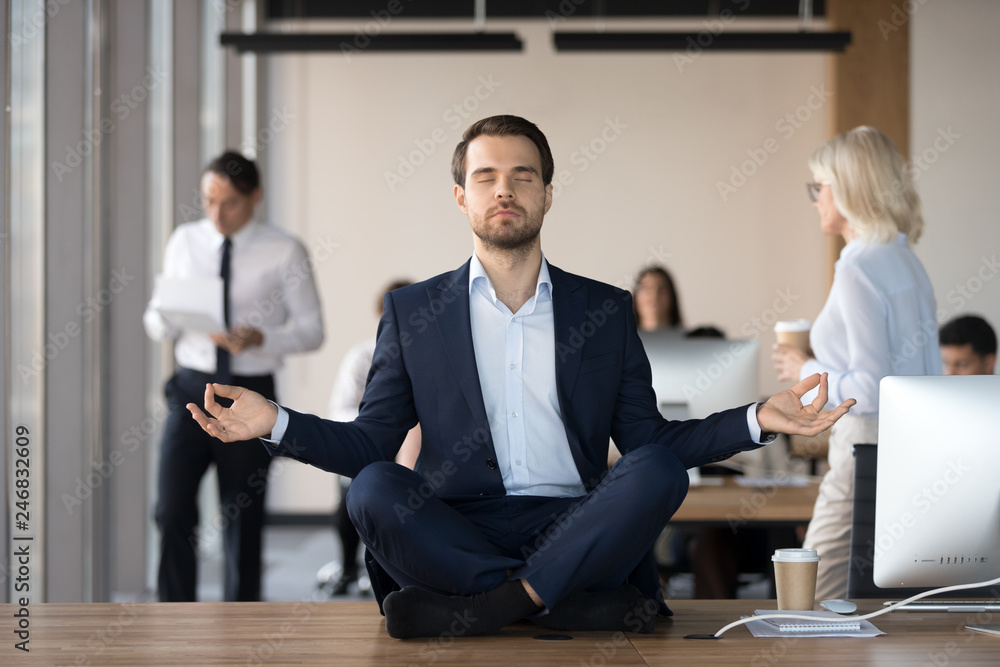 Free Photo  Businessman cheerful employee standing at yoga pose at office  on working table meditating after work