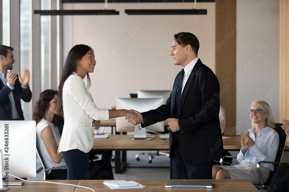 Boss shaking hand of asian employee congratulate successful worker with promotion, hiring intern, appreciate for good work while business team applaud support colleague, reward recognition concept Boss shaking hand of asian employee congratulate successful worker with promotion, hiring intern, appreciate for good work while business team applaud support colleague, reward recognition concept