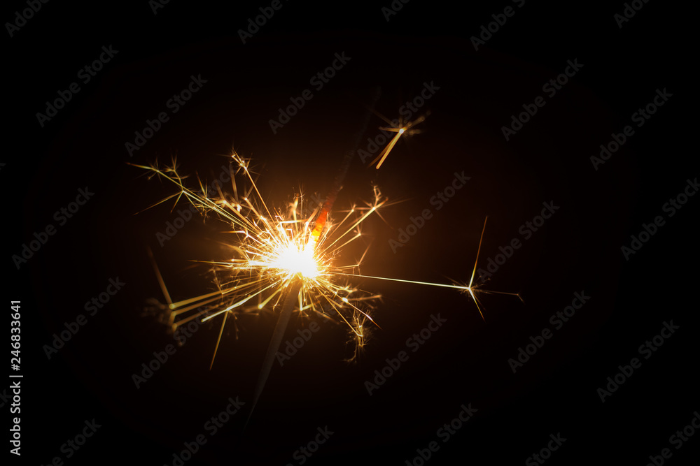 Christmas sparkler or firework on light bokeh background