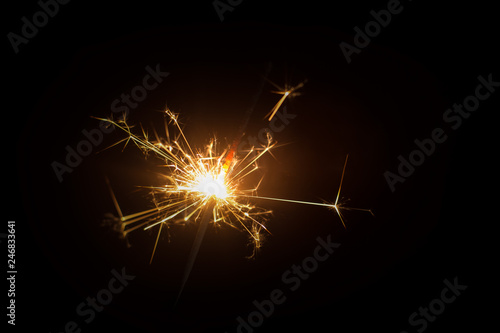 Christmas sparkler or firework on light bokeh background