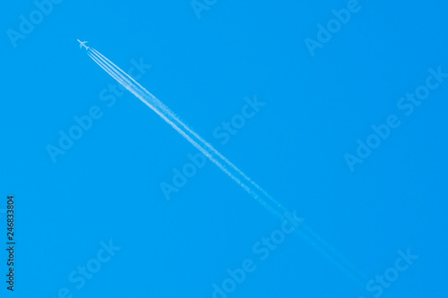 trail of a flying plane in the blue sky