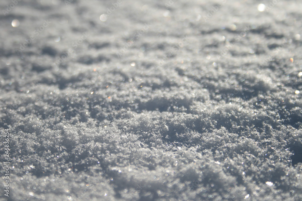 Snow surface close up, winter background with snowflakes at sunset Snow surface close up, winter background with snowflakes at sunset