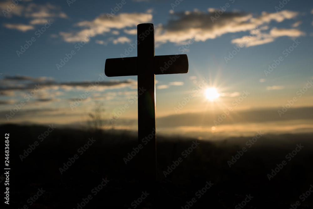 Silhouette of catholic cross and sunrise