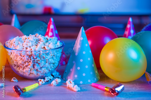 Popcorn birthday, party. On the background of TV and color bright light. Concept of festivals
