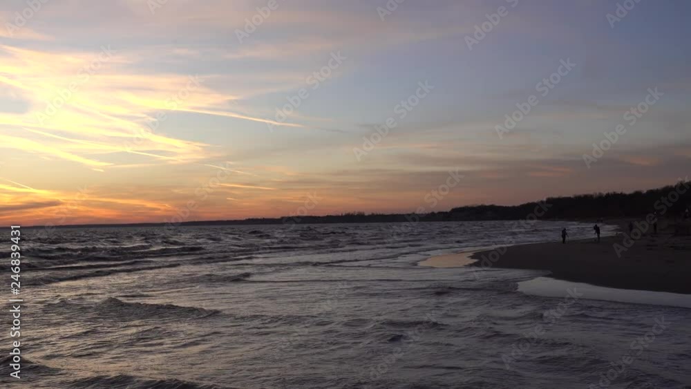 4K Waves Washing Up Against Beach With People Walking In Distance During Sunset 4K Waves Washing Up Against Beach With People Walking In Distance During Sunset