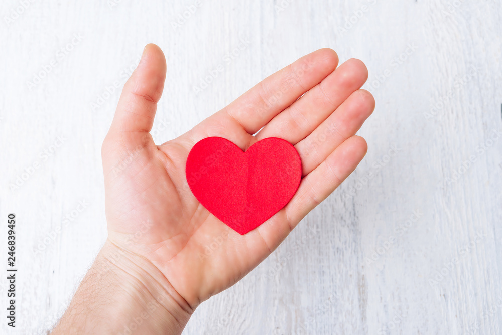 Heart shaped paper in opened palm on whit background showing love and hope. Heart shaped paper in opened palm on whit background showing love and hope.