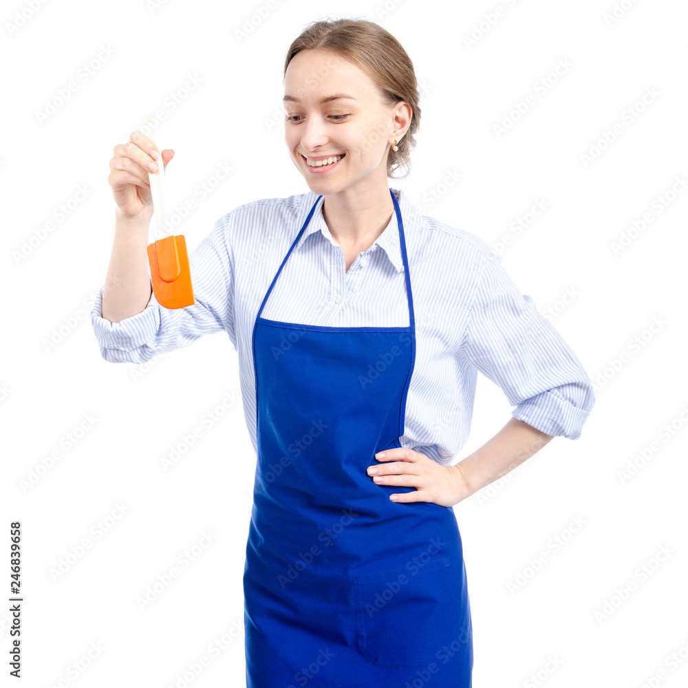 Woman in blue apron with kitchen spatula in hand on white background isolation Woman in blue apron with kitchen spatula in hand on white background isolation