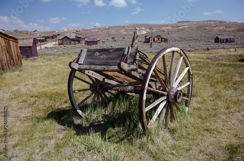 Abandoned mining equipment cart and buildings in the ghost town of Bodie, a California State Historical Park