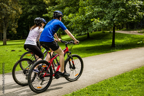 Healthy lifestyle - people riding bicycles in city park