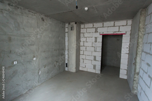 Unfinished building interior  gray room. Repairs in the apartment. Preparing in the room.