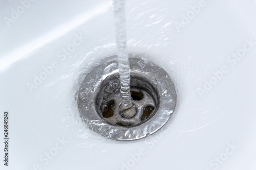 Dripping water from the single handle mixer tap mounted on a wash basin