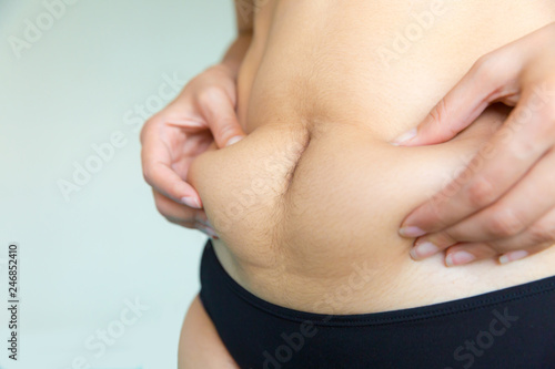 Woman catch belly fat her on white isolated © kowitstockphoto