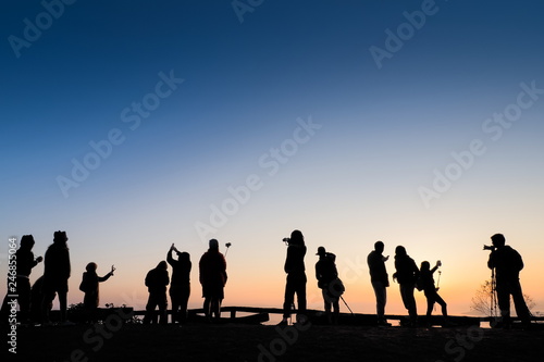view Silhouette a group of tourists on top hill with colorful of yellow sun light background, sunrise at Doi Samur Dao, Sri Nan National Park, Nan, northern of Thailand.