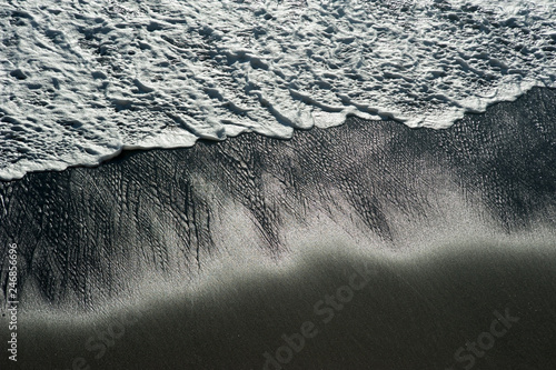 sea wave on a black pebble like a iceland beach © pavlobaliukh