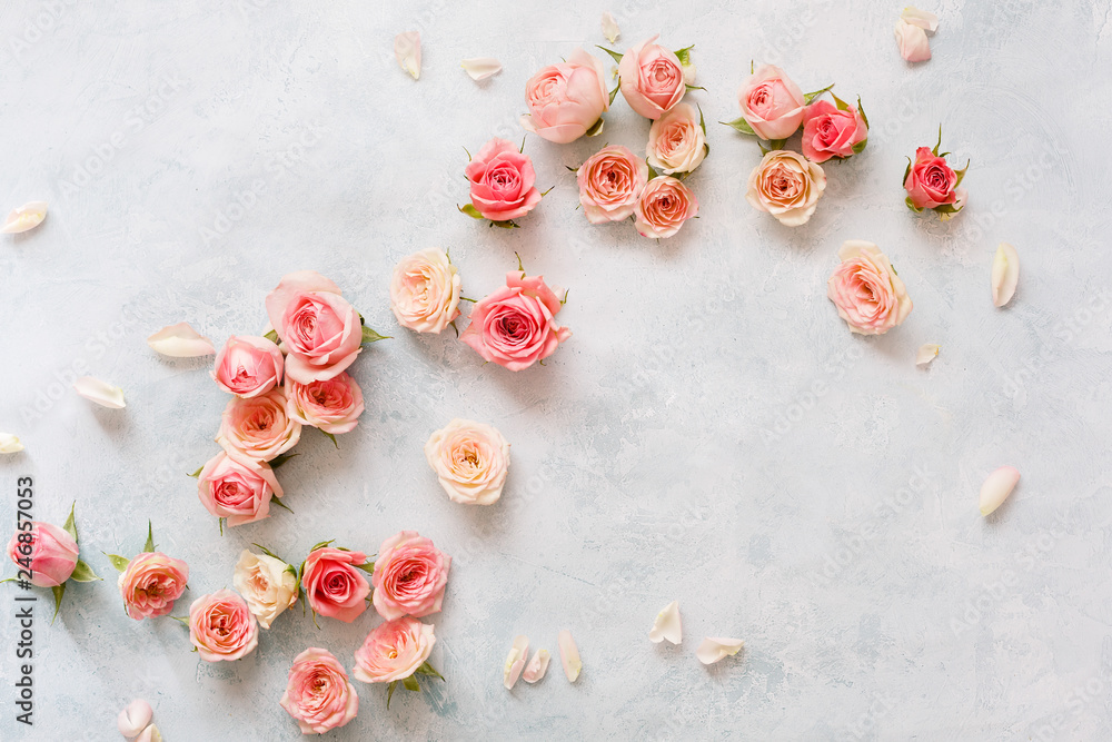 Roses On Textured Background. Various pink roses buds and petals  scattered on rustic background, overhead view, copy space - obrazy, fototapety, plakaty 
