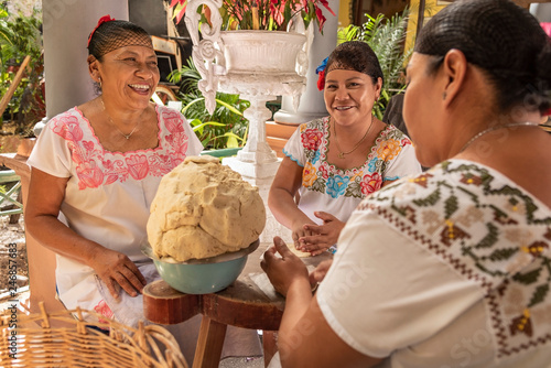 Women making Tortillas. Group of smiling cooks preparing flat bread tortillas in Yucatan, Mexico