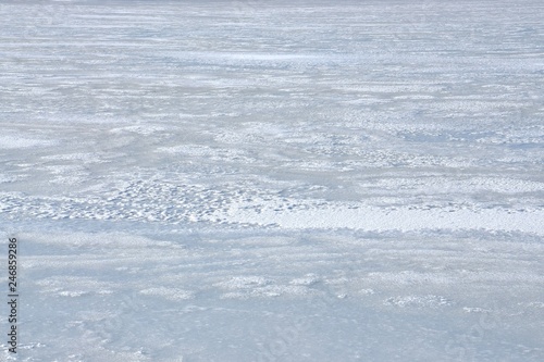 Eisdecke auf dem winterlich zugefroren See schneebedeckt im Winter © alisseja