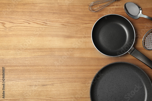 Flat lay composition with clean cookware and space for text on wooden background photo